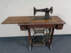 A 20th century Singer treadle sewing machine in oak table