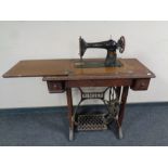 A 20th century Singer treadle sewing machine in oak table