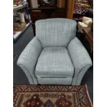 A contemporary armchair in grey upholstery