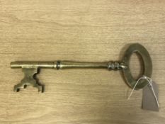 A heavy brass over-sized ornamental key, length 35 cm.