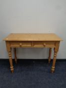 A stripped pine console table fitted two drawers