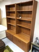 A two section teak bookcase fitted cupboards and drawers