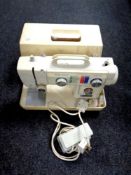 A New Home electric sewing machine in case with foot pedal