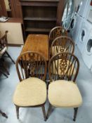 An oak drop leaf dining table together with a set of four wheel back chairs