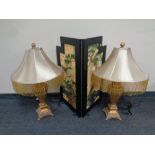 A pair of gilt composite table lamps with tasseled shades together with an oriental style two fold