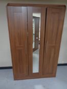 A contemporary wood effect wardrobe with central mirrored door