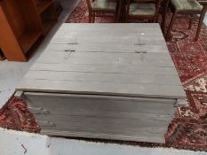 A square grey painted storage box