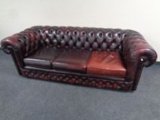 An oxblood leather Chesterfield three seater settee,