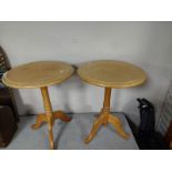 A pair of contemporary pine circular tripod tables