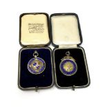 Two silver football medals,