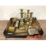 Two pairs of antique brass candlesticks together with a needlepoint three piece dressing table set