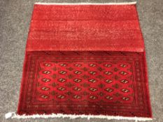 An eastern fringed cushion cover on red ground,