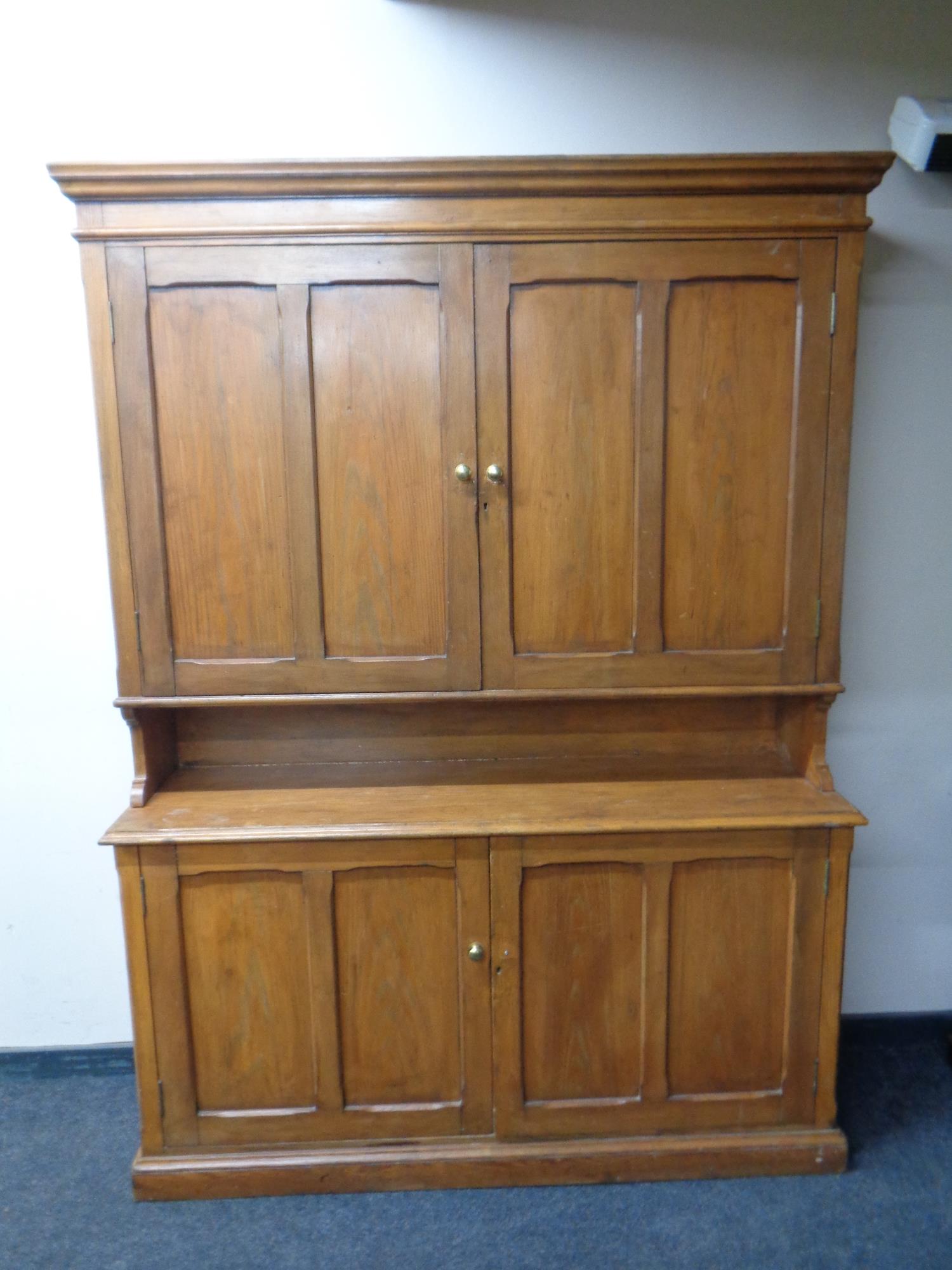 An antique pine double door housekeeper's cabinet fitted cupboards beneath, height 214 cm,