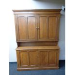 An antique pine double door housekeeper's cabinet fitted cupboards beneath, height 214 cm,