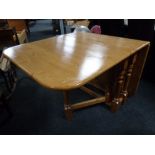 A contemporary pine drop leaf table