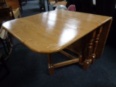 A contemporary pine drop leaf table