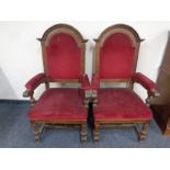 A pair of Edwardian oak high backed armchairs upholstered in a red dralon