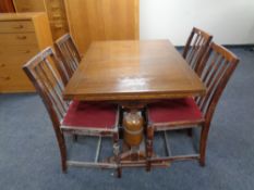 A 20th century oak pull out dining table together with a set of four rail back chairs