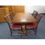 A 20th century oak pull out dining table together with a set of four rail back chairs