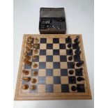 A wooden chess set with pieces together with a box containing dominoes