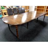 A stained pine flap end dining table with six extension leaves,