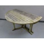 A slatted teak drop leaf garden table