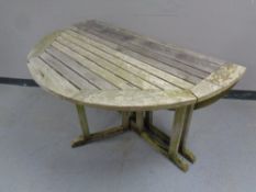 A slatted teak drop leaf garden table