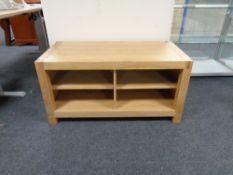 A contemporary oak television stand fitted shelves beneath,