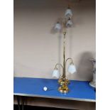 A contemporary brass standard lamp with opaque glass shades,