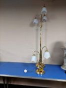 A contemporary brass standard lamp with opaque glass shades,