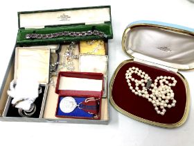 A collection of costume jewellery to include faux pearls, brooches, wristwatch,