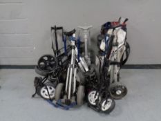 A quantity of assorted folding golf trolleys together with a golf bag,
