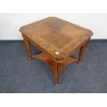 A reproduction French style two tier table in a walnut finish