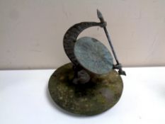 A bronze sundial mounted on a circular stone base