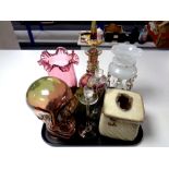 A tray of milk glass table lustre, ruby glass vase, glass model of a skull,