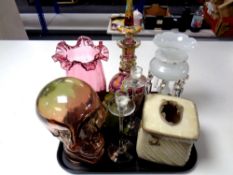 A tray of milk glass table lustre, ruby glass vase, glass model of a skull,