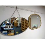 An early 20th century oval frameless mirror together with a further shaped mirror in composite