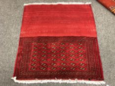 An eastern fringed cushion cover on red ground,