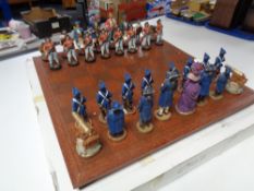 A chess board with figural pieces,