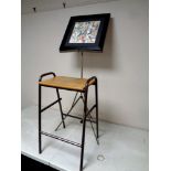 A 20th century school stool together with a folding music stand and a watercolour depicting figures,