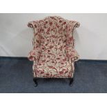 A wingback armchair upholstered in a floral fabric