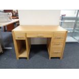 A contemporary oak twin pedestal computer desk fitted five drawers,