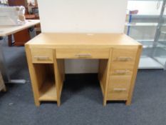 A contemporary oak twin pedestal computer desk fitted five drawers,