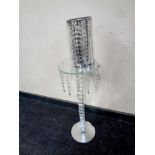 A contemporary glass and crystal wine table with drops together with a contemporary table lamp