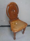An Edwardian carved pitch pine hall chair