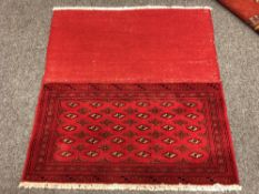 An eastern fringed cushion cover on red ground,