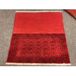 An eastern fringed cushion cover on red ground,