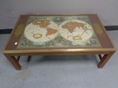 A brass bound glass topped coffee table depicting a map of the world