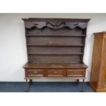 A Georgian oak kitchen dresser fitted three drawers beneath on raised legs, height 206 cm,