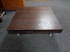 An Ikea square low coffee table on metal legs,